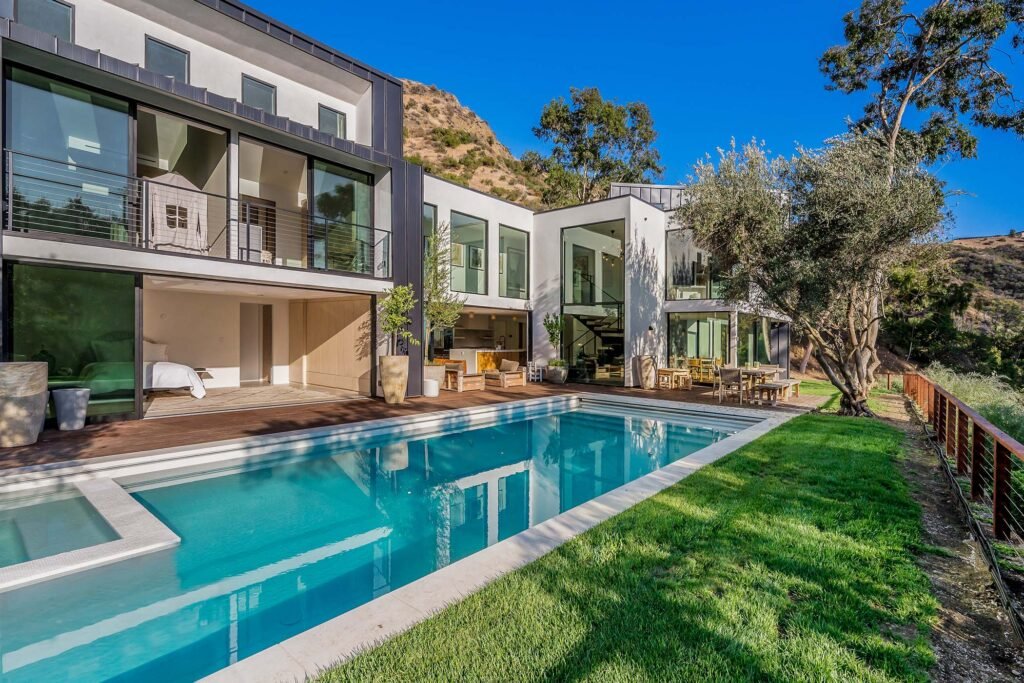 a-house-that-has-swimming-in-the-grass-around-it